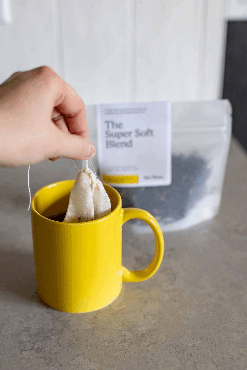 a hand dunks custom tea into a real thread yellow mug