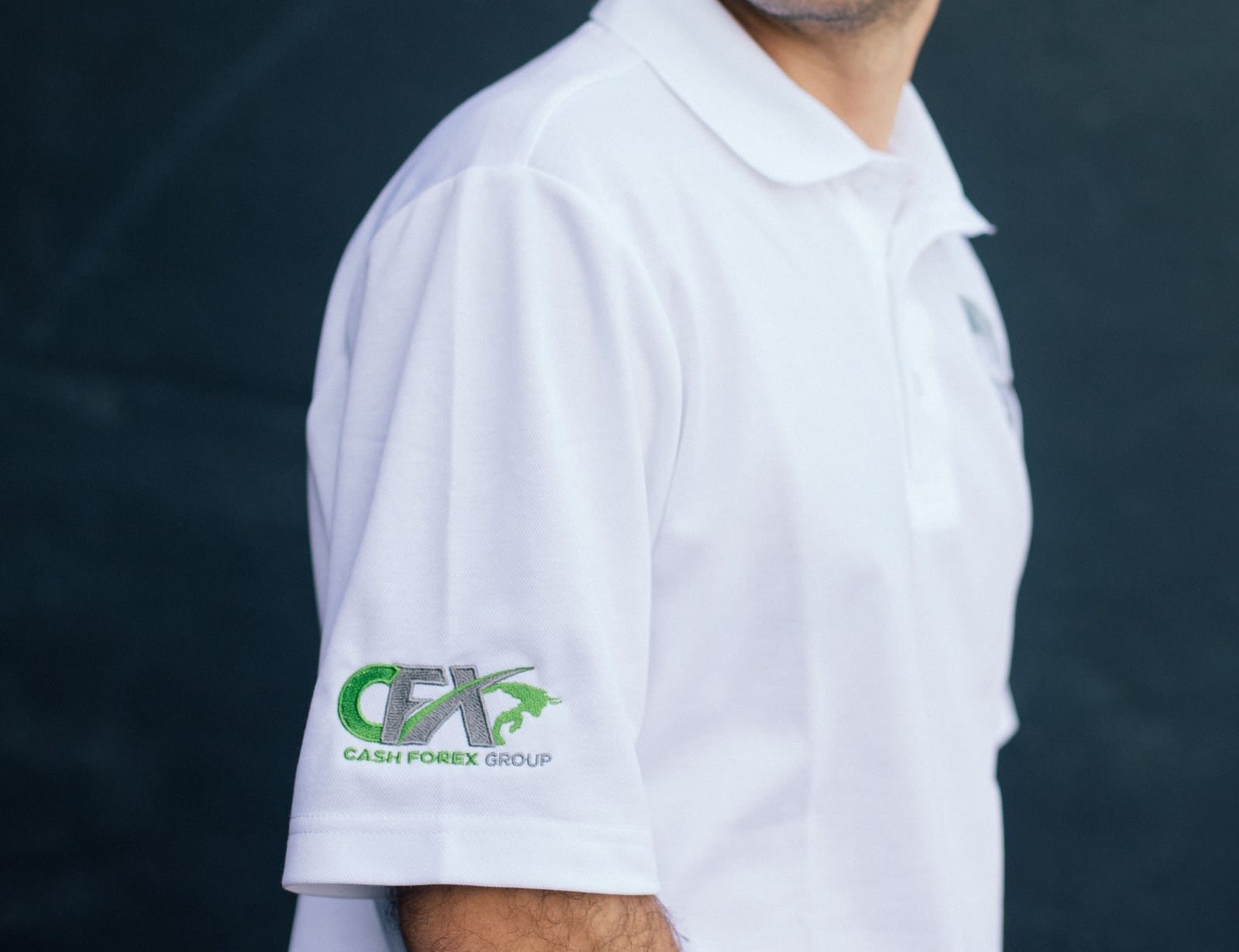 A white polo with custom embroidery on the front chest and sleeve