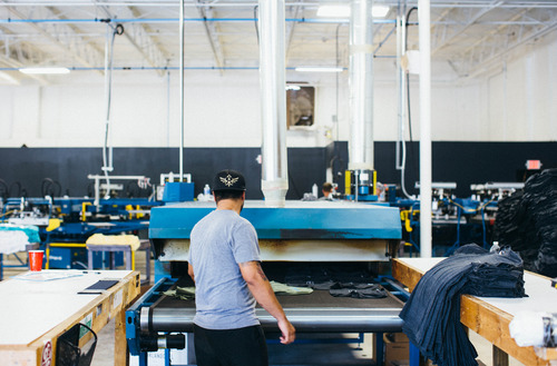 man putting shirts on dryer