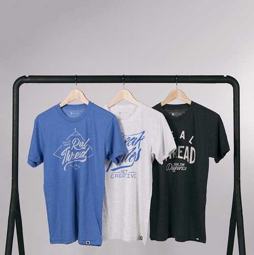 three t-shirts hanging on rack