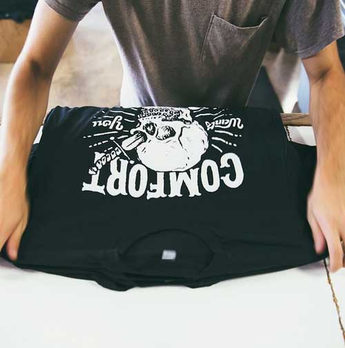 man inspecting black shirt with white print