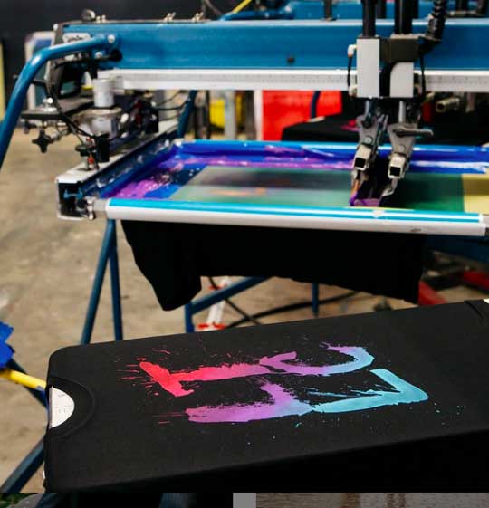 black shirt with colorful graphic on a press