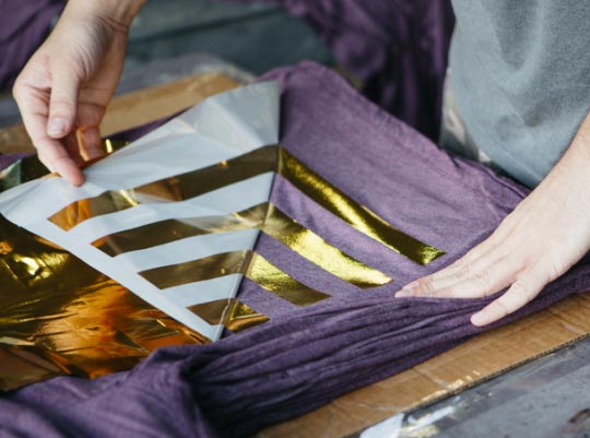 pulling old foil from a purple shirt