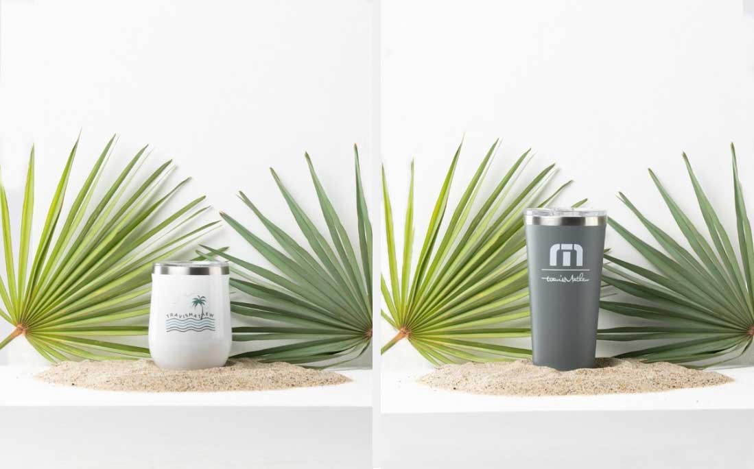 two thermoses in front of palm branches